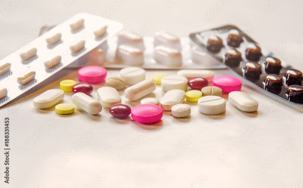 Close-up of the pills on the white background, The drug and capsule pills on the floor, Pile of the drug and pills on the white background. Close-up of the pills on the white background, The drug and capsule pills on the floor, Pile of the drug and pills on the white background.