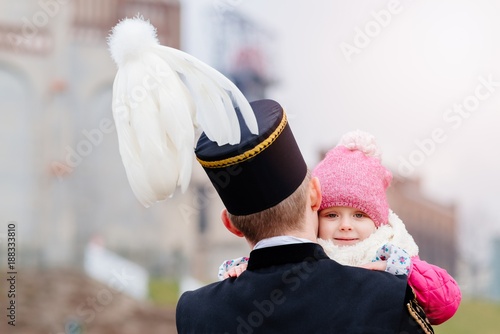 Black coal miner in gala uniform with his child.