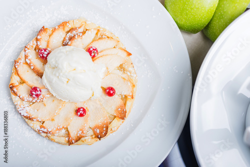 Fresh fragrant cake apple strudel on a white plate with an ice cream ball.