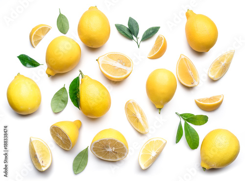 Fototapeta Ripe lemons and lemon leaves on white background. Top view.