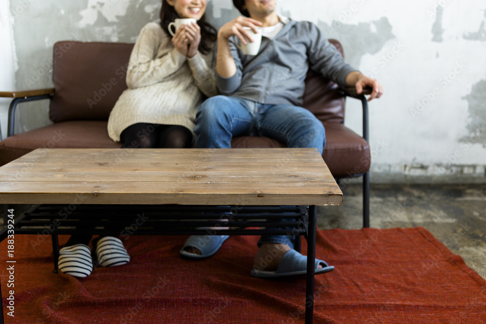 Naklejka premium テレビを見ながらコーヒーを飲む若い夫婦