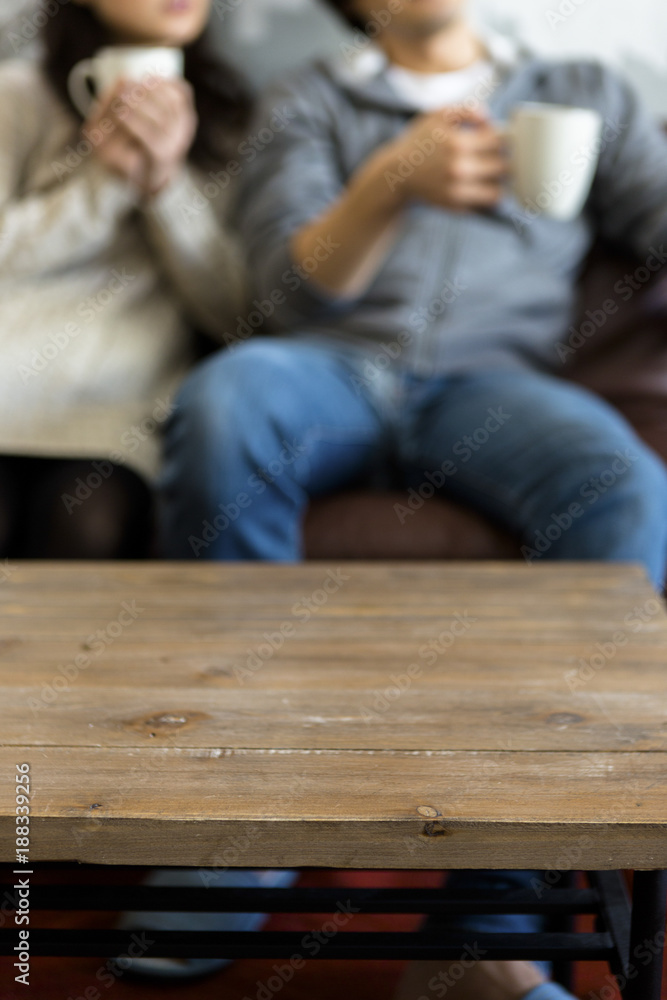 テレビを見ながらコーヒーを飲む若い夫婦 テレビを見ながらコーヒーを飲む若い夫婦