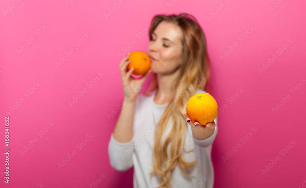 Girl with two orange fruits on pink background Girl with two orange fruits on pink background