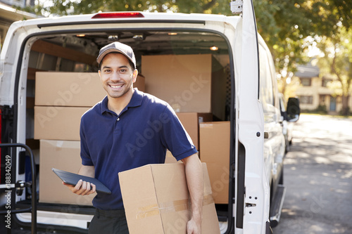 Portrait Of Courier With Digital Tablet Delivering Package