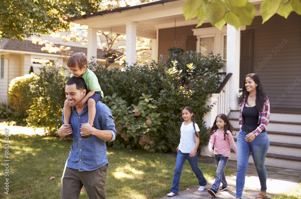Fototapeta premium Father Gives Son Ride On Shoulders As Family Leave House