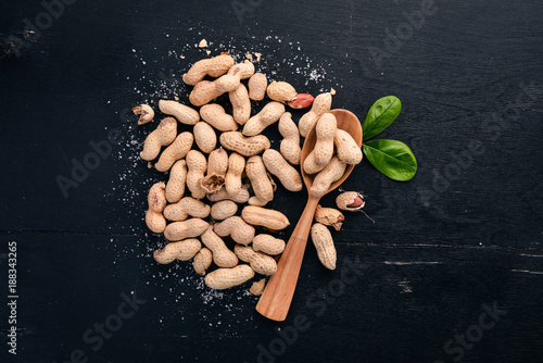 Peanuts on a dark wooden background. Healthy snacks. Top view. Free space for text.