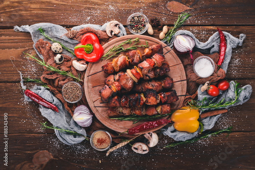 Marinated baked kebab with onions and spices. On a wooden background. Top view. Free space for text.
