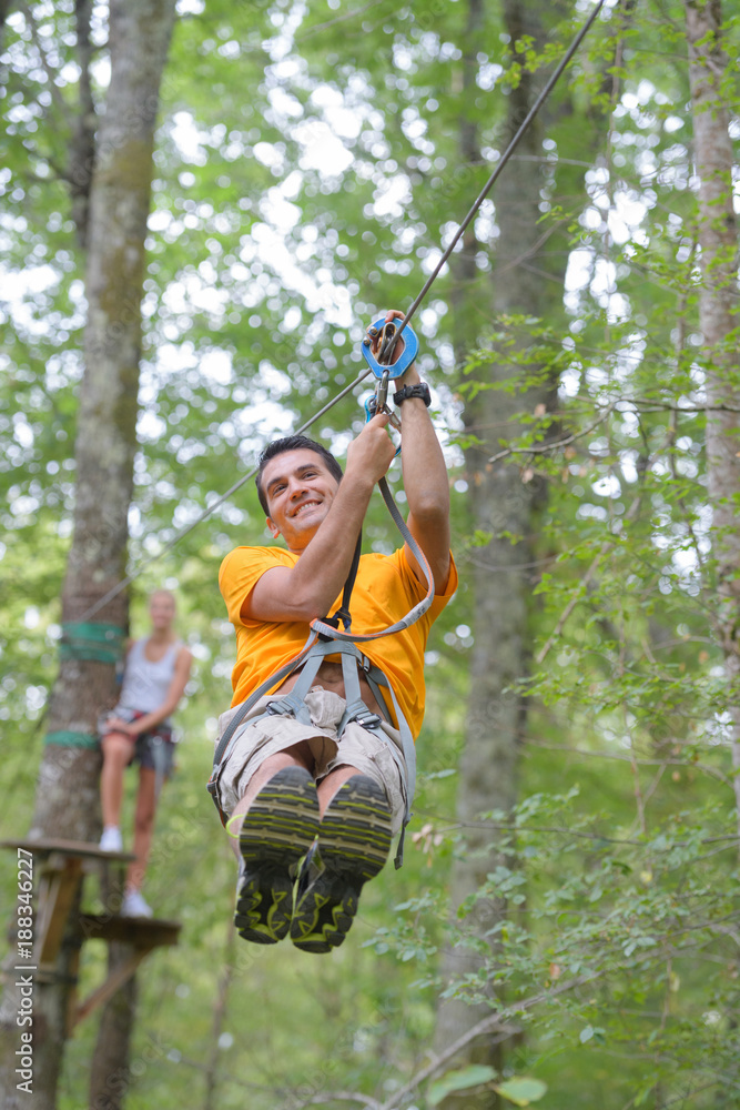 a man ziplines through the forest in lao a man ziplines through the forest in lao