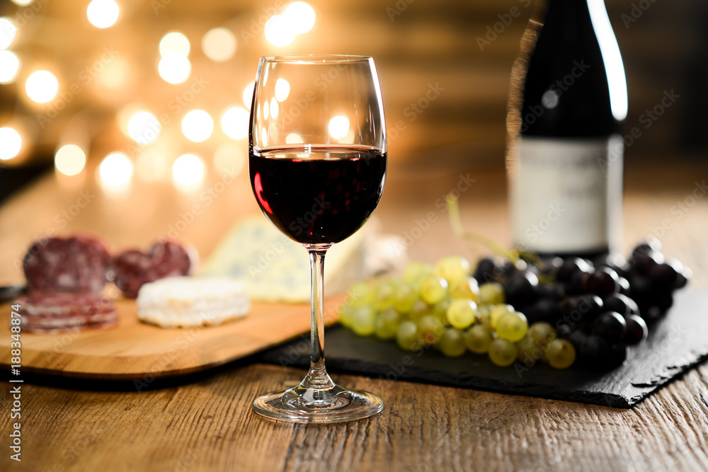 Φωτογραφία glass of red wine with french cheese and delicatessen in restaurant wooden table