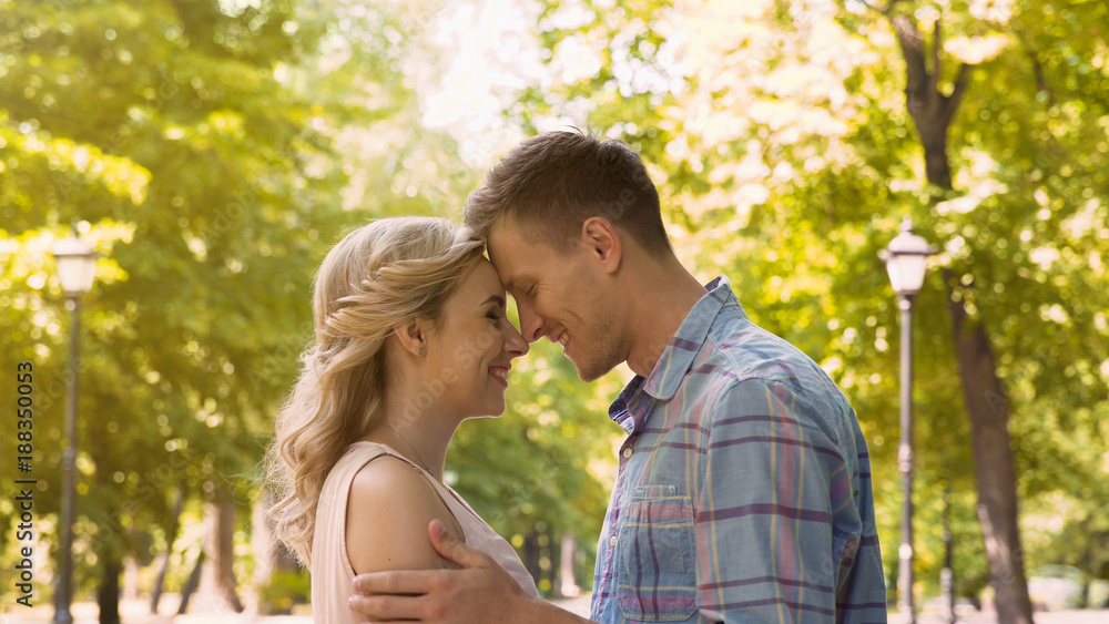 Couple in love gently embracing, enjoying each other on date in park, first love Couple in love gently embracing, enjoying each other on date in park, first love