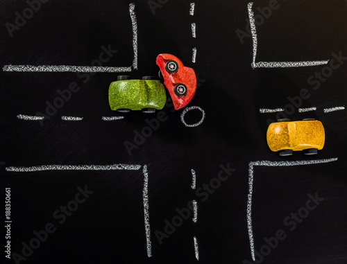 Green wooden car toy crashed Red wooden car toy on the crossroad on Chalk board