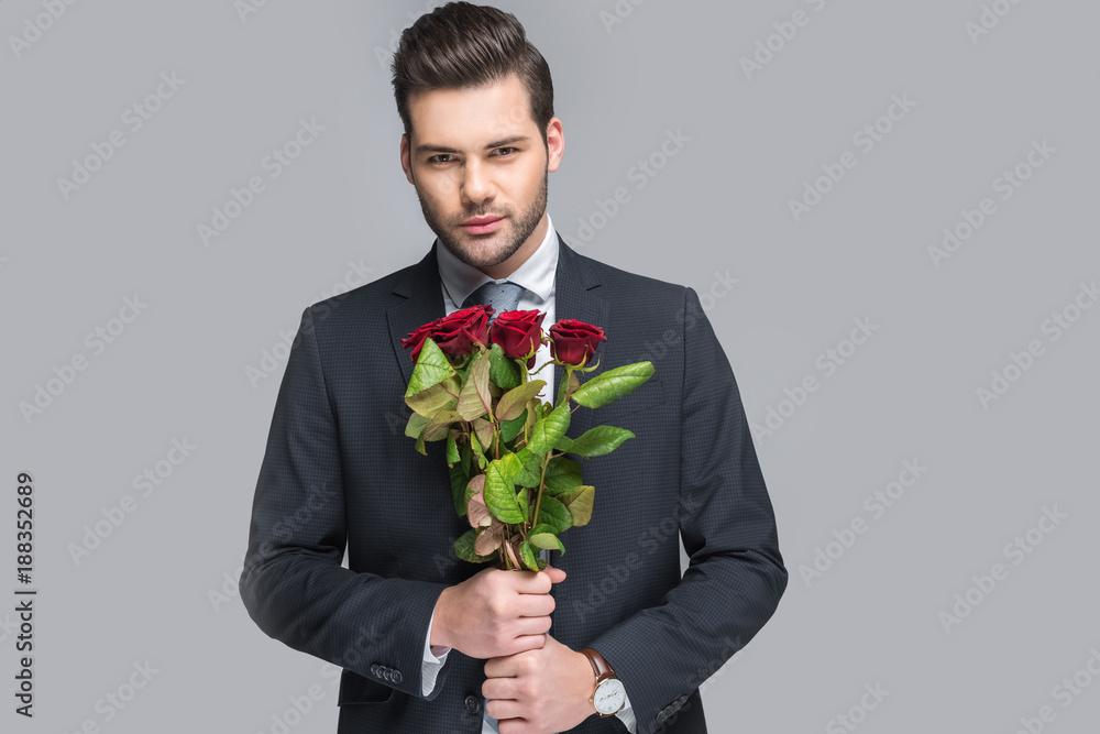 elegant man holding bouquet of red roses, isolated on grey elegant man holding bouquet of red roses, isolated on grey
