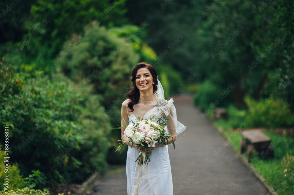 beautiful bride holding a wedding bouquet of flowers and posing