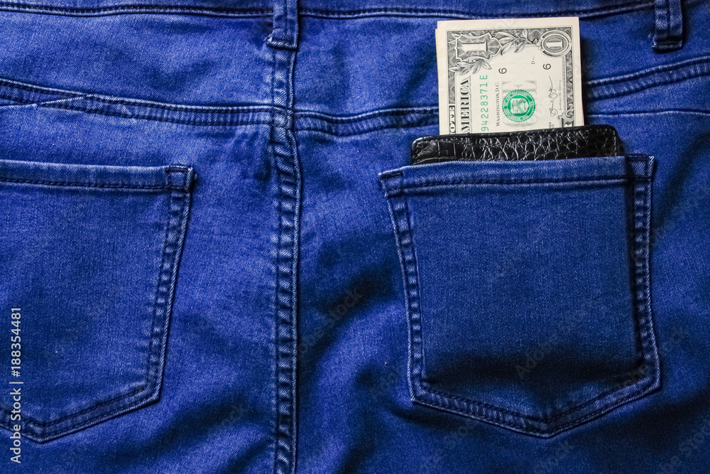 Black leather wallet with money in back blue jeans pocket denim background texture. Black leather wallet with money in back blue jeans pocket denim background texture.