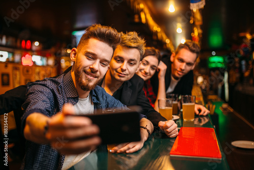 Happy football fans makes selfie at bar counter