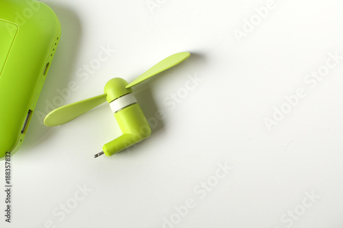 A flat lay of a green mini fan to a power bank