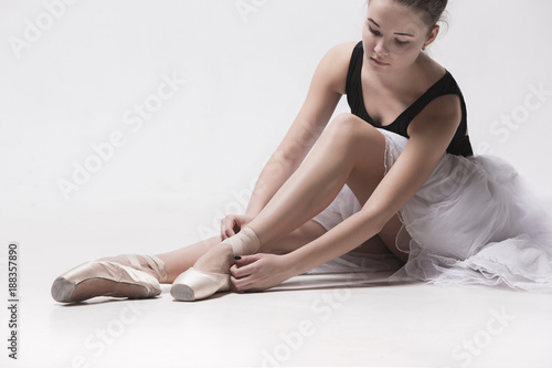 Ballerina dancer sitting down with her legs crossed