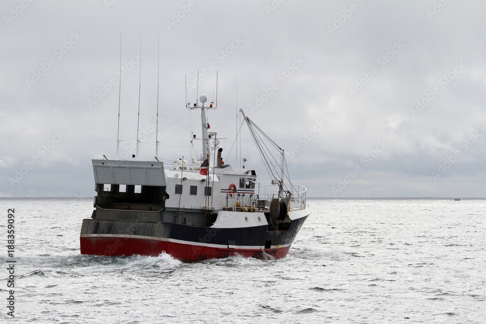 chalutiers en mer pris à contre-jour