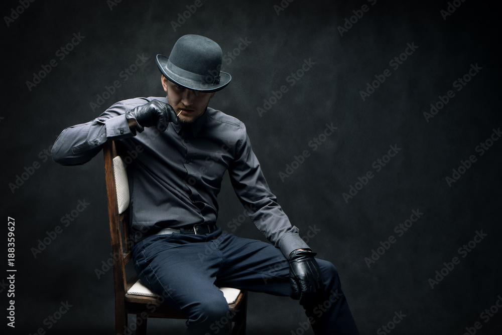 The criminal and robber in black gloves are sitting on a chair The criminal and robber in black gloves are sitting on a chair