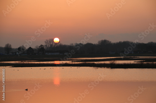 Sunset over the river rotte and waterstorage of the Eendragtspolder in Zevenhuizen, Netherlands photo