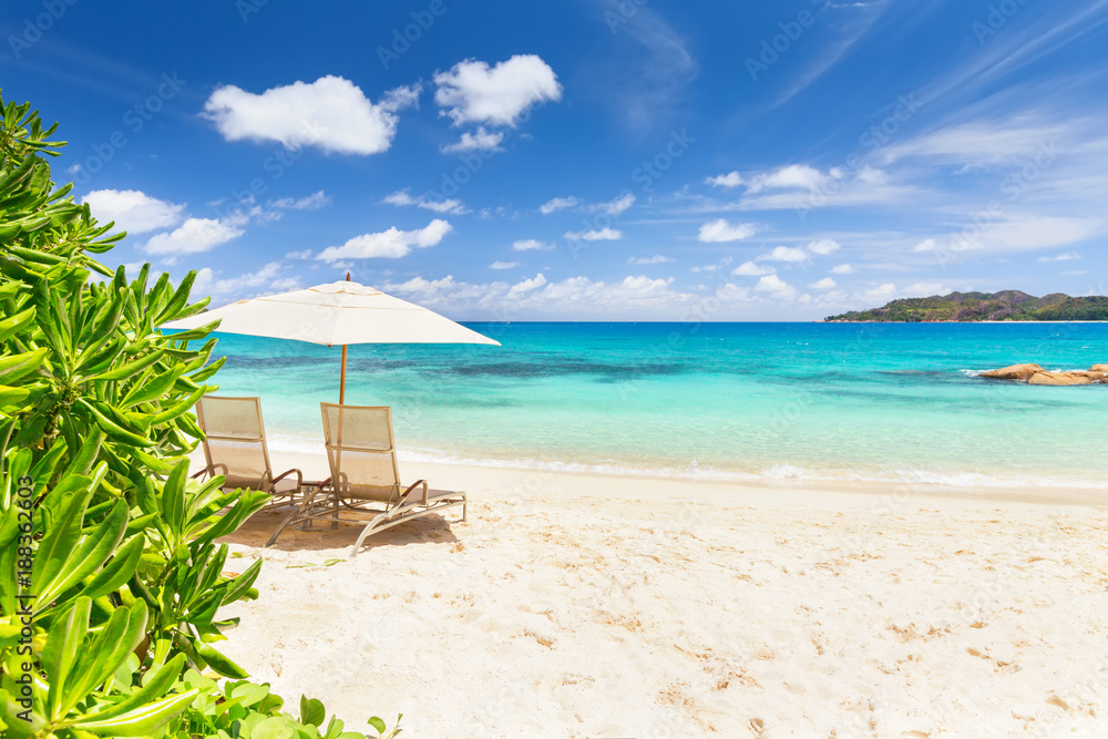 Obraz premium Pair of chairs and an umbrella on the beach of Praslin island, Seychelles