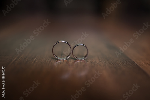 Beautiful wedding rings lie on a wooden surface photo