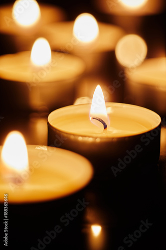Canvastavla Burning tea light candles in darkness