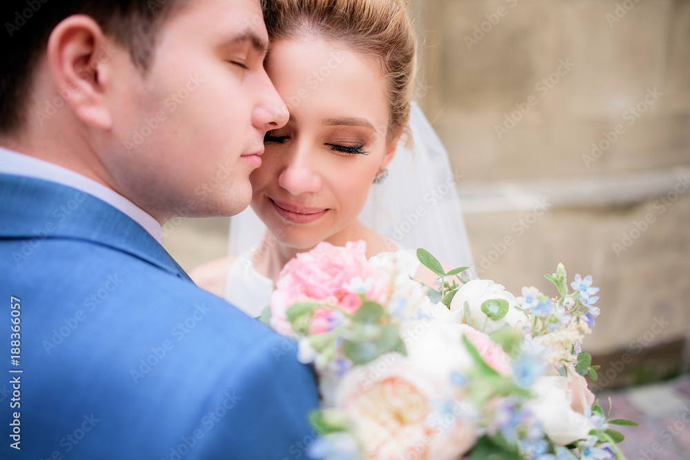 Portrait of stunning bride leaning to a groom in blue suit tender Portrait of stunning bride leaning to a groom in blue suit tender