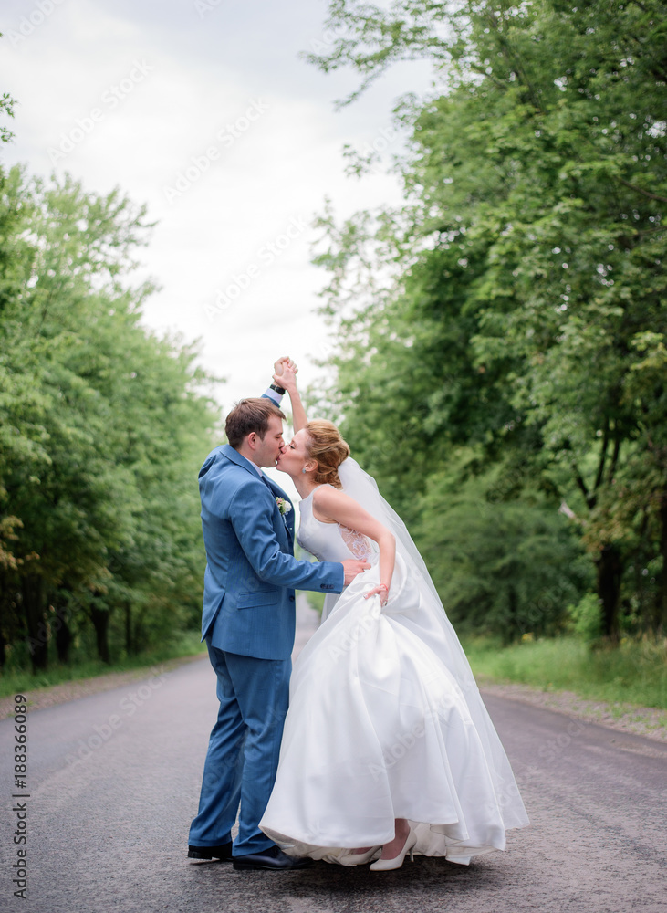 Bride and groom look gorgeous walking in a green summer park Bride and groom look gorgeous walking in a green summer park