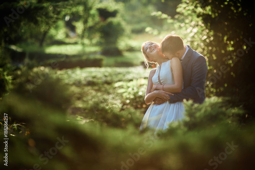 Bride and groom look gorgeous walking in a green summer park