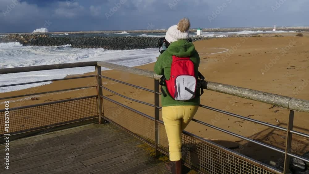 woman photographer working during a storm in Biarritz France woman photographer working during a storm in Biarritz France