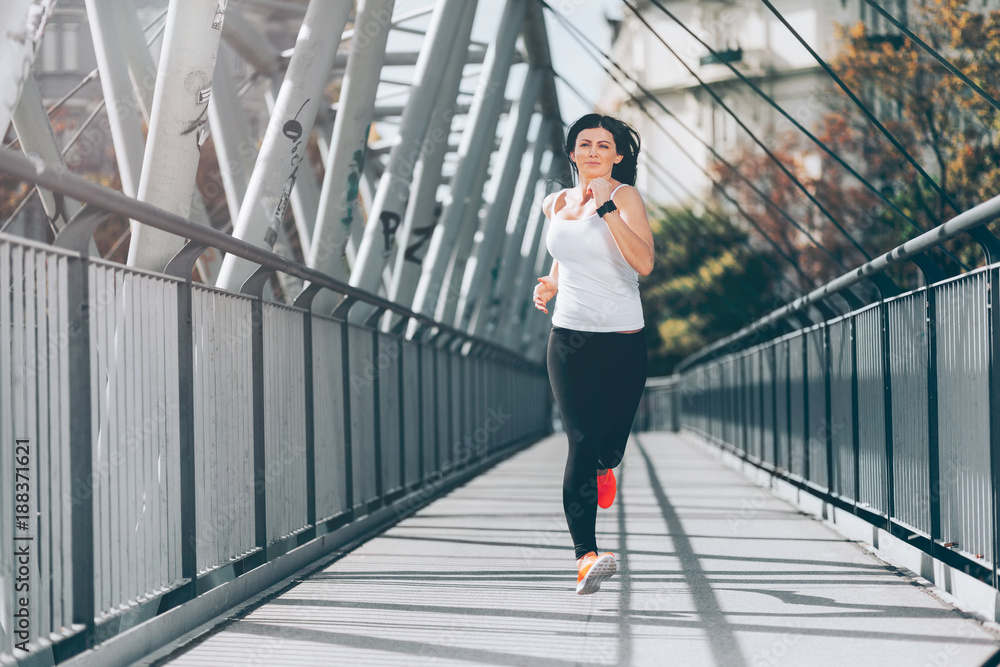 City workout. Beautiful woman running in an urban setting City workout. Beautiful woman running in an urban setting