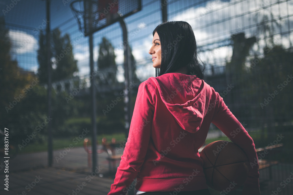 Fototapeta premium Female basketball player training outdoors on a local court