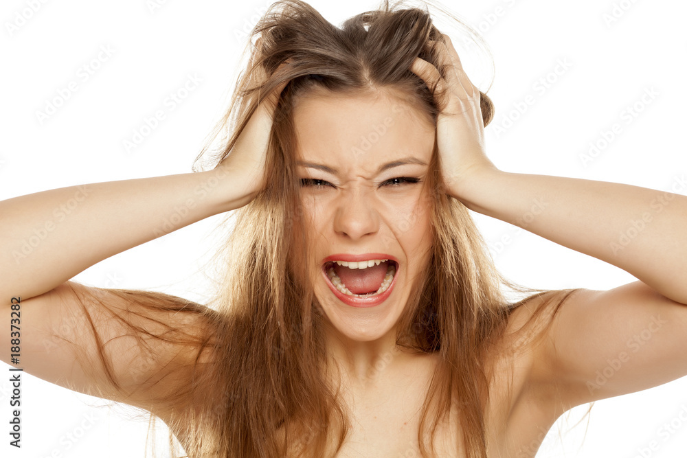 very nervous young girl with messy hair screaming on a white background very nervous young girl with messy hair screaming on a white background