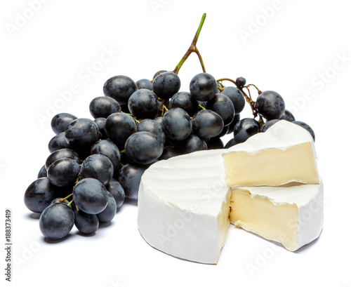Round brie or camambert cheese and grapes on a white background
