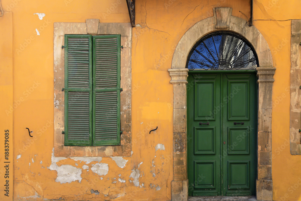 Fototapeta premium old green door and window of ancient yellow building