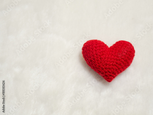 handmade red yarn heart on white wool. the red heart on the right of picture and background copy space for text. Valentines day  love concept and love background