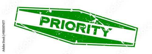 Grunge green priority wording hexagon rubber seal stamp on white background