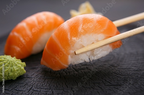 Eating sushi. Delicious Japanese cuisine, nigiri sushi with salmon served with wasabi and ginger, close up. Restaurant concept