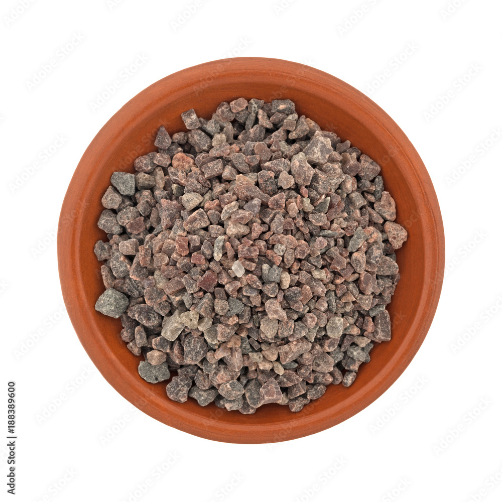 Top view of a small terracotta bowl filled with Himalayan black salt isolated on a white background. Top view of a small terracotta bowl filled with Himalayan black salt isolated on a white background.