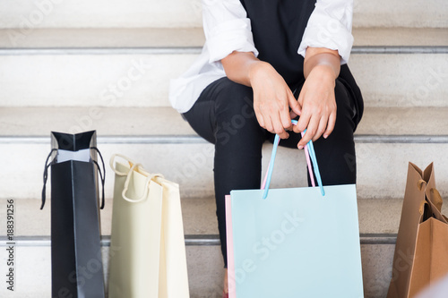 Woman sit at the stair with shopping bag after shopping all day and she was tired.