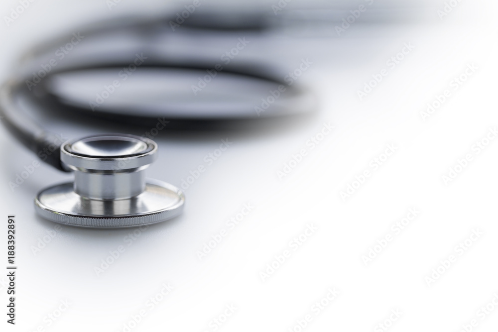 Black stethoscope in shallow depth-of-field isolated on white background with side copy space for text area. Black stethoscope in shallow depth-of-field isolated on white background with side copy space for text area.