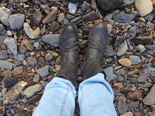 Füße stehen auf Steinen am Ufer eines Flusses