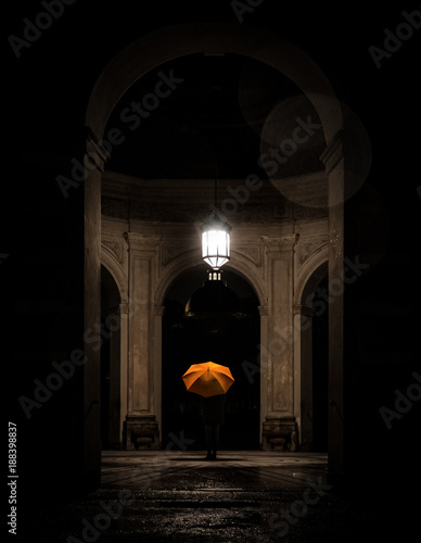 Young Woman with orange umbrella standing in a temple in the dark in Hofgarten Munich by night // Junge Frau mit orangenem Regenschirm bei Nacht im Dunkel in einem Tempel im Hofgarten München