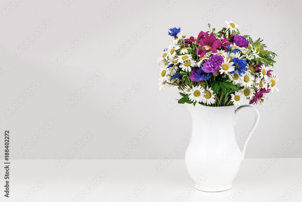 Wildflowers in white ceramic jug.
