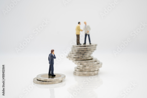 Miniature toy: Business man discussing about business on stack of coin and one man thinking how to success like that team, business ,financial, Success, Business Growth concept.