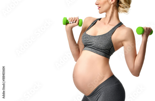 Pregnant woman doing sport stretching exercises green weights. Pregnancy motherhood expectation healthy life and weight control concept
