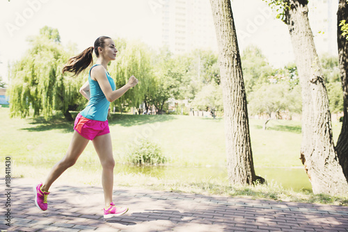 Athletic woman running by the lake in the park