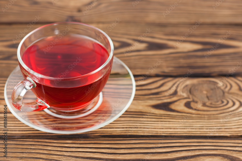 Fototapeta premium Full cup of red tasty raspberry tea on old wooden rustic table
