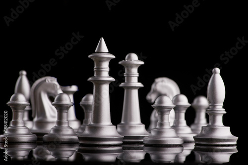 Silver set chess pieces on a black